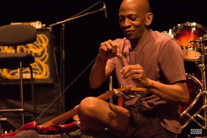 Portrait de Reggie Washington en train de corder sa basse