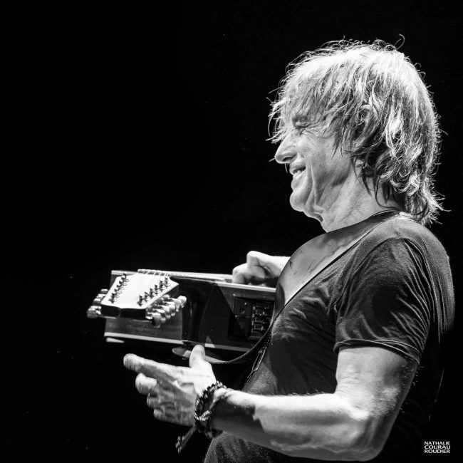 Portrait de Jean-Louis Aubert en concert à la guitare 12 cordes