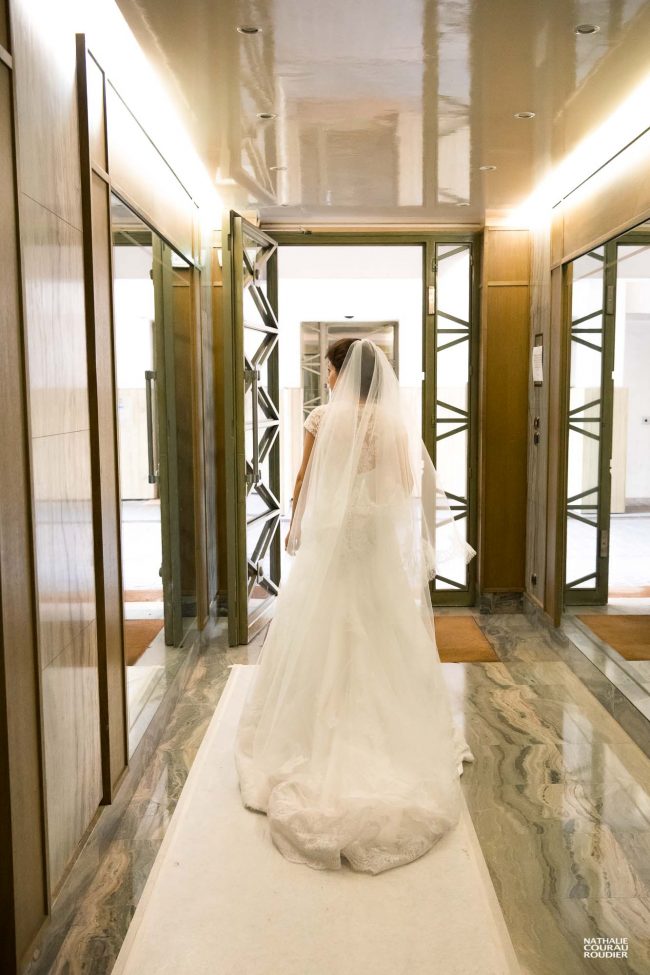 Mariage à Paris : la mariée dans le hall de son immeuble en route pour l'église - photographe Nathalie Courau Roudier