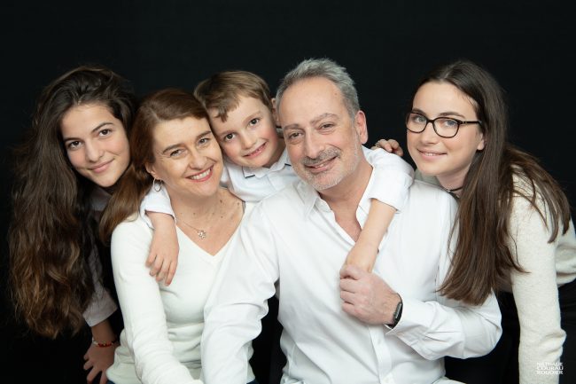 Photo en studio de famille habillée en blanc sur fond noir