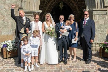 Photo de famille à la sortie de la messe de mariage - Photographe Nathalie Courau-Roudier