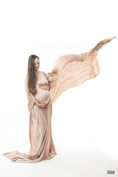 photo studio de grossesse. Future maman dans un voile en soie qui s'envole