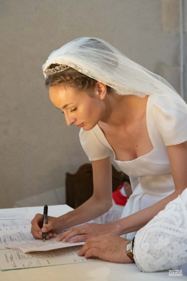 La mariée signe les registres à la fin de la messe de mariage - Photographe Nathalie Courau-Roudier