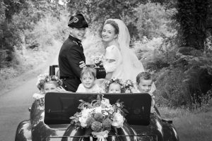 Portrait des mariés en voiture entre l'église et leur réception de mariage