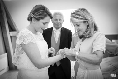 Préparation du mariage : la maman de la mariée lui attache son bracelet - Photographe Nathalie Courau-Roudier
