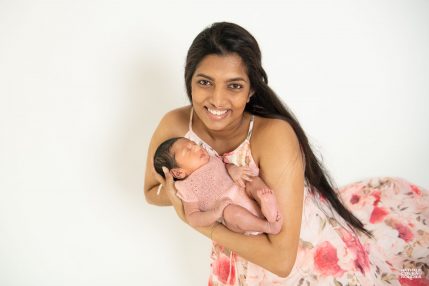 Photo studio Naissance, Maman en robe à fleurs porte son bébé