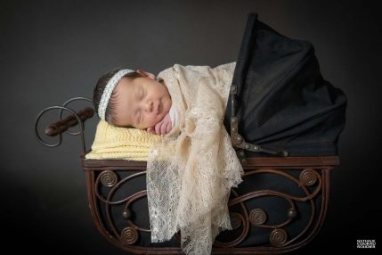 Photo studio Naissance, nouveau-né installé dans un landau de poupée vintage, couverture jaune et dentelle